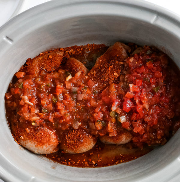 slow cooker with chicken and salsa in it for chicken tacos