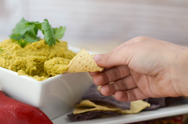 spicy guacamole dip being served with a chip