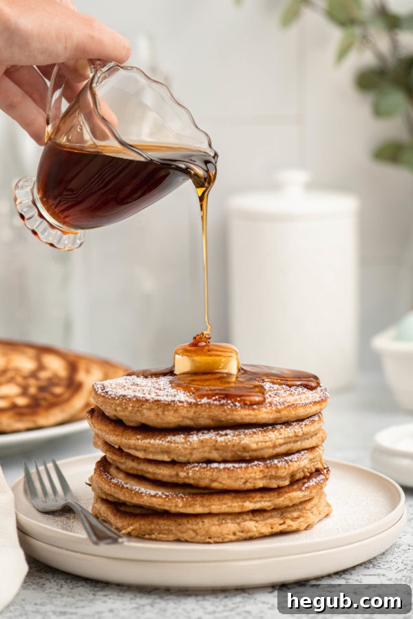 Warm Spiced Ginger Flapjacks 2 Festive Ginger Pancakes topped with powdered sugar and maple syrup, ready for a cozy holiday breakfast