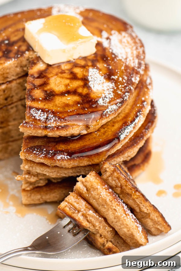 Warm Spiced Ginger Flapjacks 7 A close-up shot of ginger pancakes stacked and drizzled with syrup and powdered sugar
