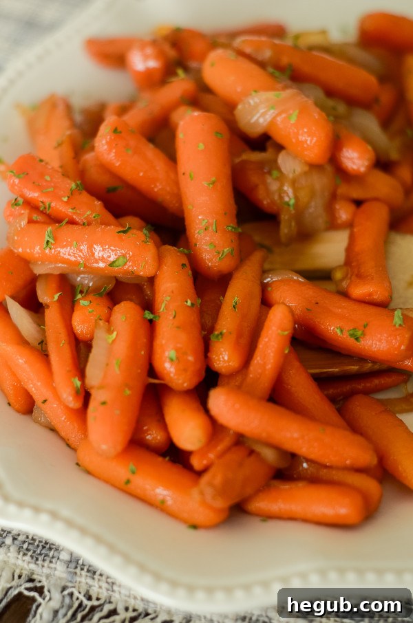 Apple Cider Glazed Carrots in a serving bowl, garnished with fresh herbs