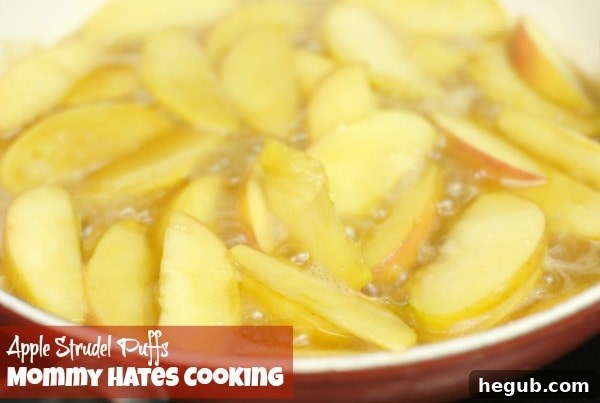 Caramelized apple slices simmering in a skillet with butter and brown sugar, preparing for the strudel filling.