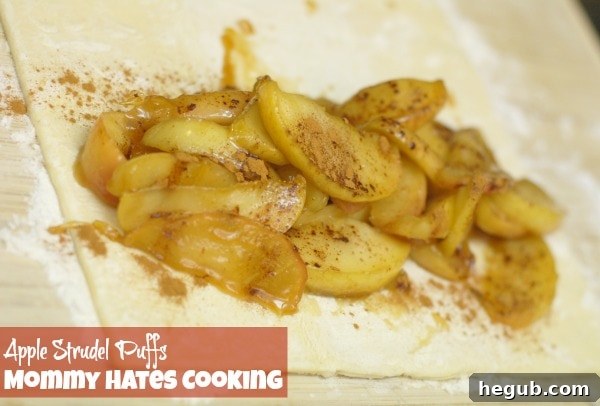 Cooked apple filling spooned onto one half of a Pepperidge Farm puff pastry sheet, ready for folding.
