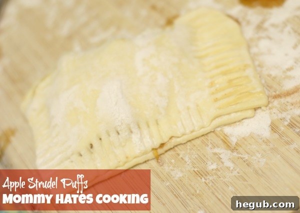 Puff pastry sheet folded over apple filling, then sliced into three individual strudel portions.