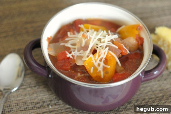 A close-up shot of the Italian stew, showing tender beef, diced tomatoes, and vibrant peppers.