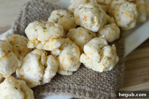 Freshly baked gluten-free cheddar bay biscuits with melted garlic butter glaze on a baking sheet