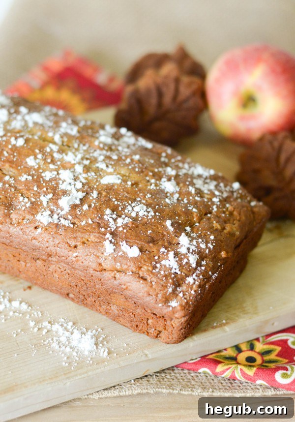 Delicious Gluten-Free Caramel Apple Bread loaf, sliced, with apples in the background