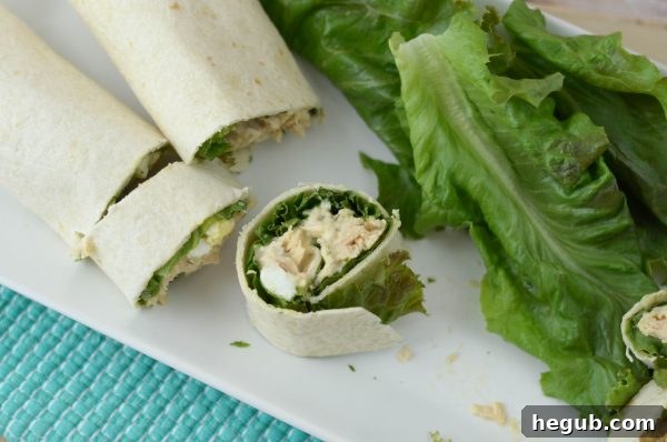 A child's hand reaching for a Tuna Salad Pinwheel from a lunchbox, highlighting convenience.