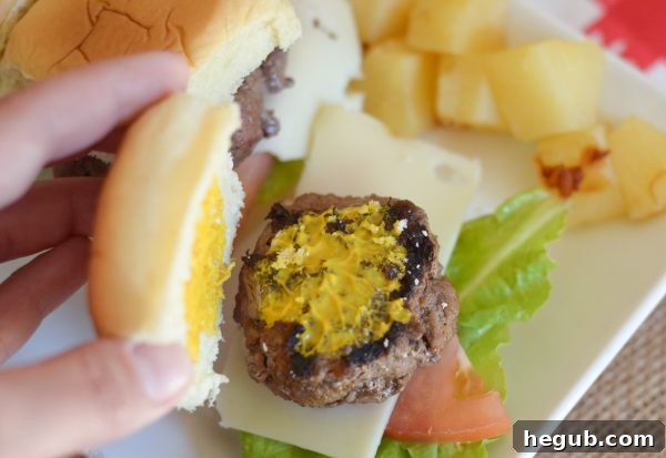 Closeup of a single Hawaiian Beef Slider on a Hawaiian roll with French's Ketchup