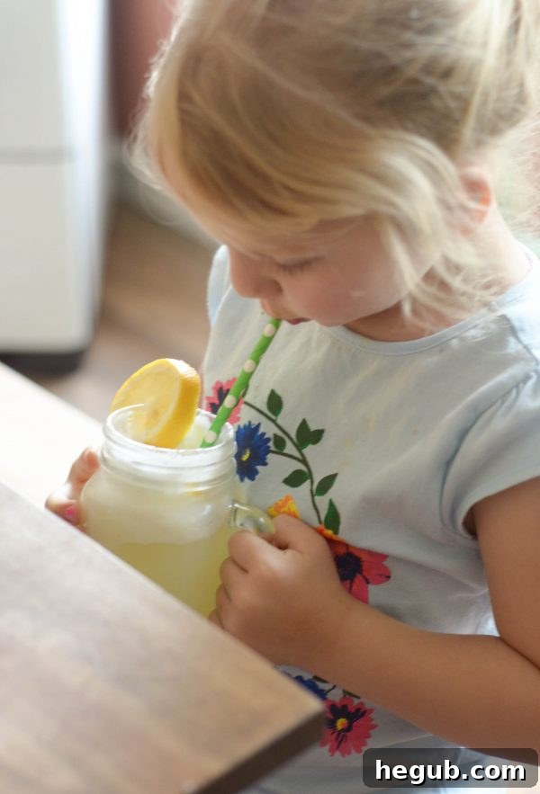 Golden Citrus Cooler 5 Lemonade Punch being poured into a cup