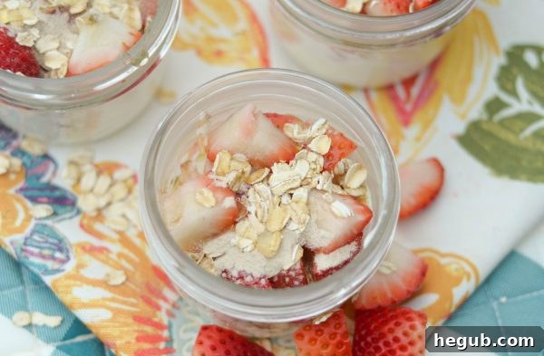Layered strawberry smoothie ingredients in a mason jar, part of a prep-ahead breakfast strategy