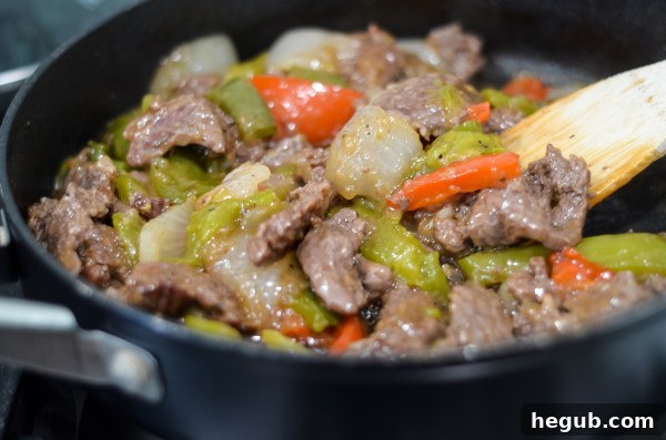 Creamy Beef and Peppers simmering in a large skillet