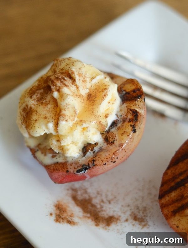Close-up of grilled cinnamon butter peaches with melted vanilla ice cream.