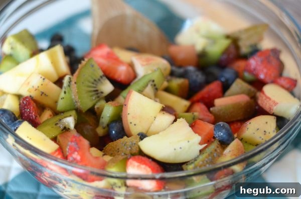 Effortless Poppy Seed Fruit Medley 3 Close-up shot of Poppy Seed Fruit Salad, showcasing the diverse colors and textures of the fruits and the light sheen of the poppy seed dressing. Focus on fresh, ripe ingredients.