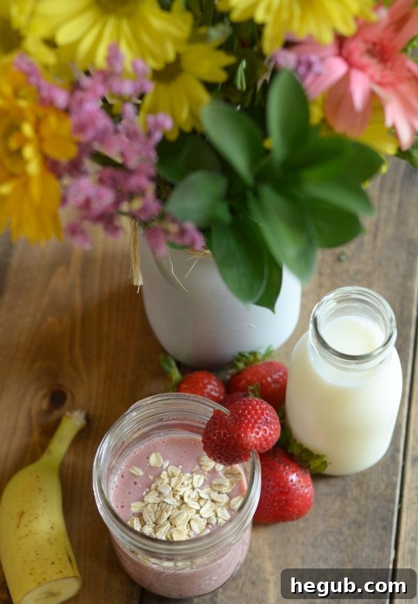 A vibrant Strawberry Banana Oat Smoothie in a clear glass, showcasing the creamy blend of fruits, oats, and dairy.