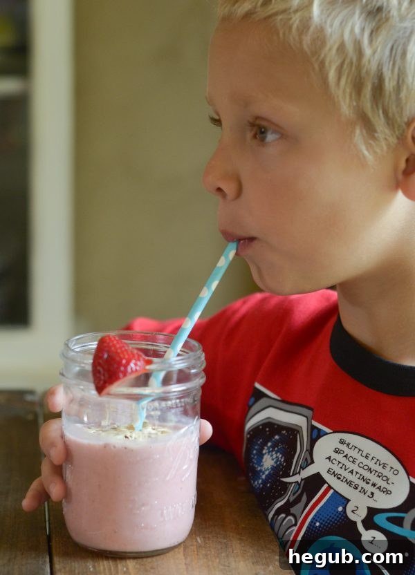 Refreshing Strawberry Banana Oat Smoothie with a straw, showcasing its thick and creamy texture, ideal for a morning energy boost.