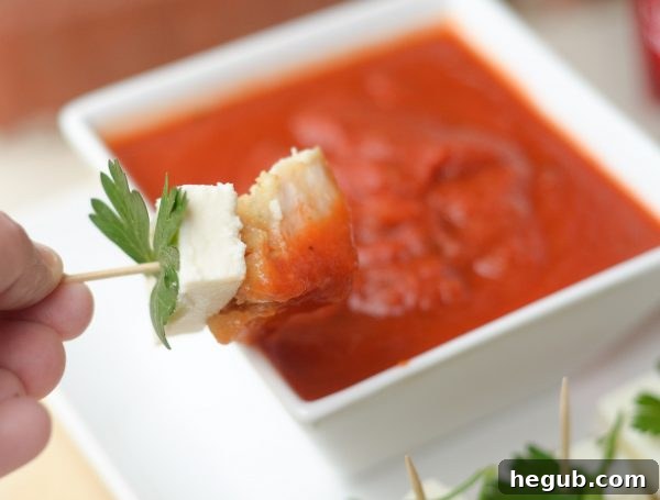 Platter of Parmesan Herb Bites with marinara sauce, garnished with fresh parsley, ready to serve as an elegant holiday appetizer.