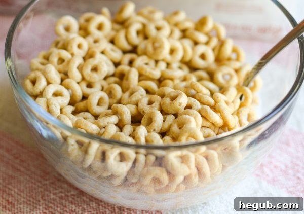 Two children happily eating Maple Cheerios for breakfast at the kitchen table.