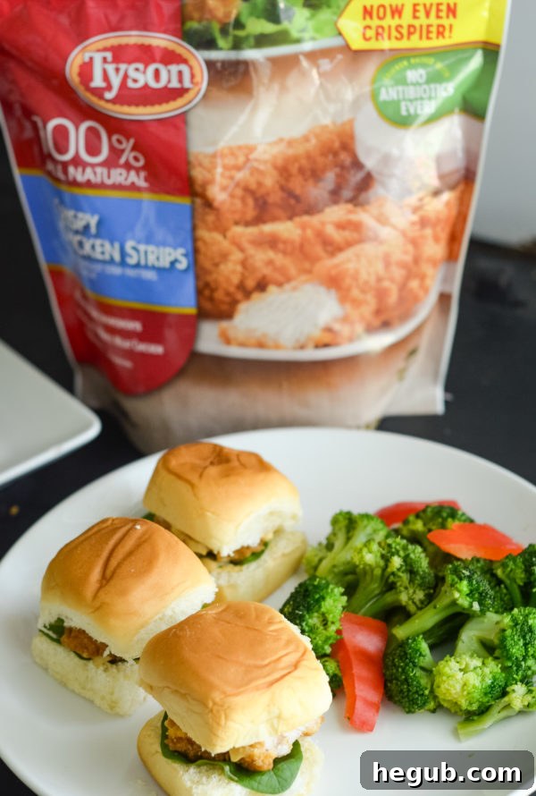 Two hands holding crispy chicken sliders