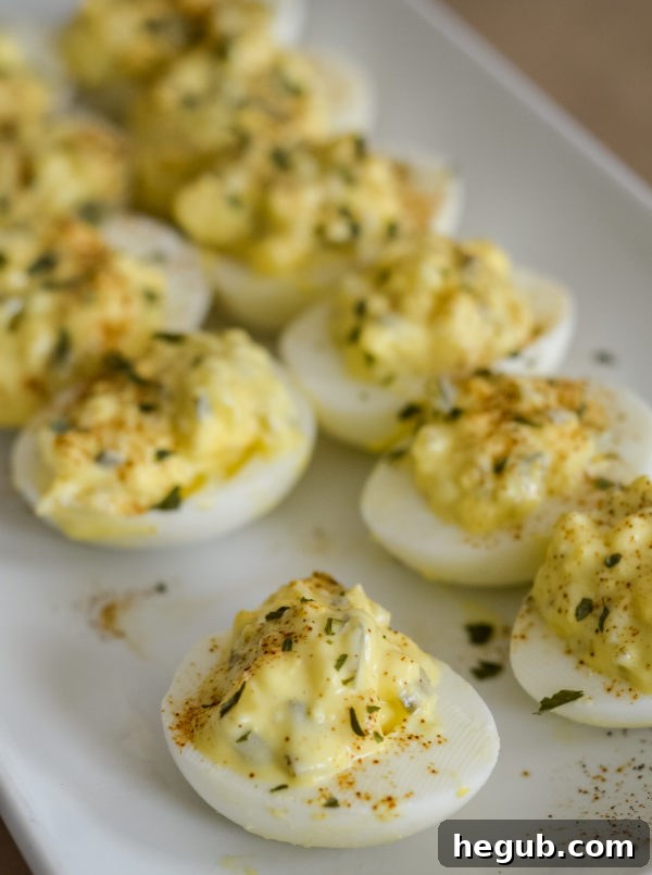 A vibrant platter of freshly prepared deviled eggs, garnished with a sprinkle of paprika, ready to be served as an appetizer.