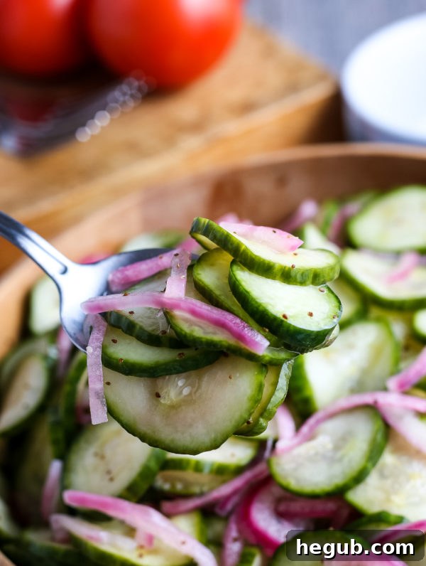 Close-up of easy cucumber salad, showing crisp slices of cucumber and red onion