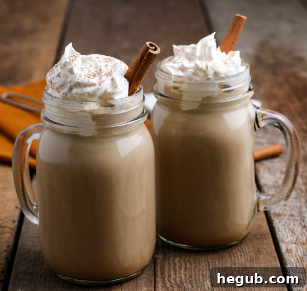 A freshly made pumpkin spice latte in a glass mug, with whipped cream and a sprinkle of spice, ready to be enjoyed.