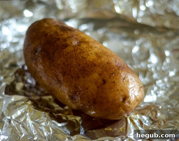 Smoked baked potatoes wrapped in foil on the grill