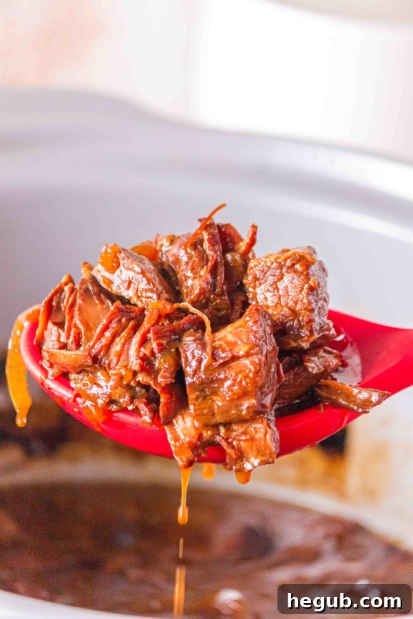 Sliced onions and cubed flank steak in slow cooker