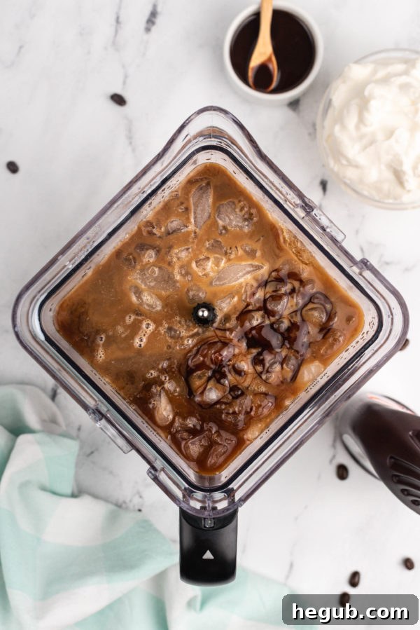 Close-up of frozen mocha coffee topped with homemade whipped cream and chocolate syrup, ready to be enjoyed.