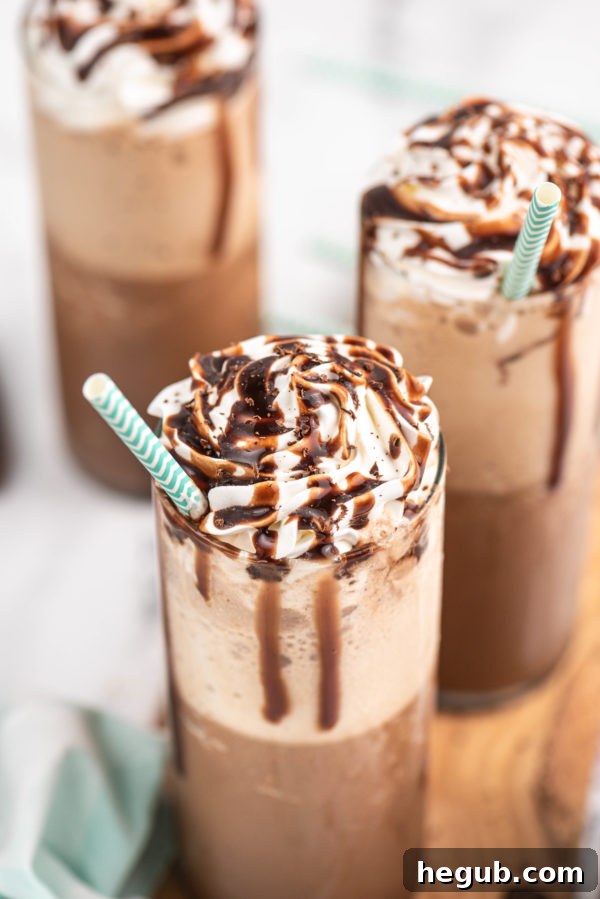 Close-up of a chilled glass of frozen mocha coffee, garnished with whipped cream and chocolate drizzle.