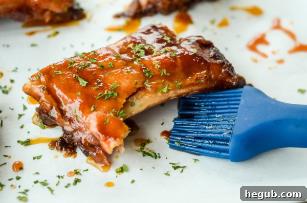 This image shows brushing barbecue sauce onto slow cooker apple bbq ribs.