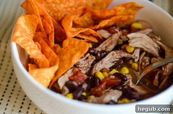 Effortless Slow Cooker Chicken Taco Soup 5 bowl of slow cooker chicken taco soup with avocado and chips