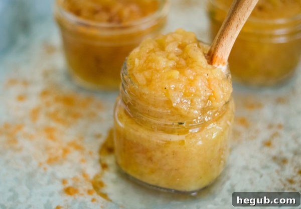 Freshly cooked applesauce still in the pressure cooker pot, showing a soft, mashed consistency.